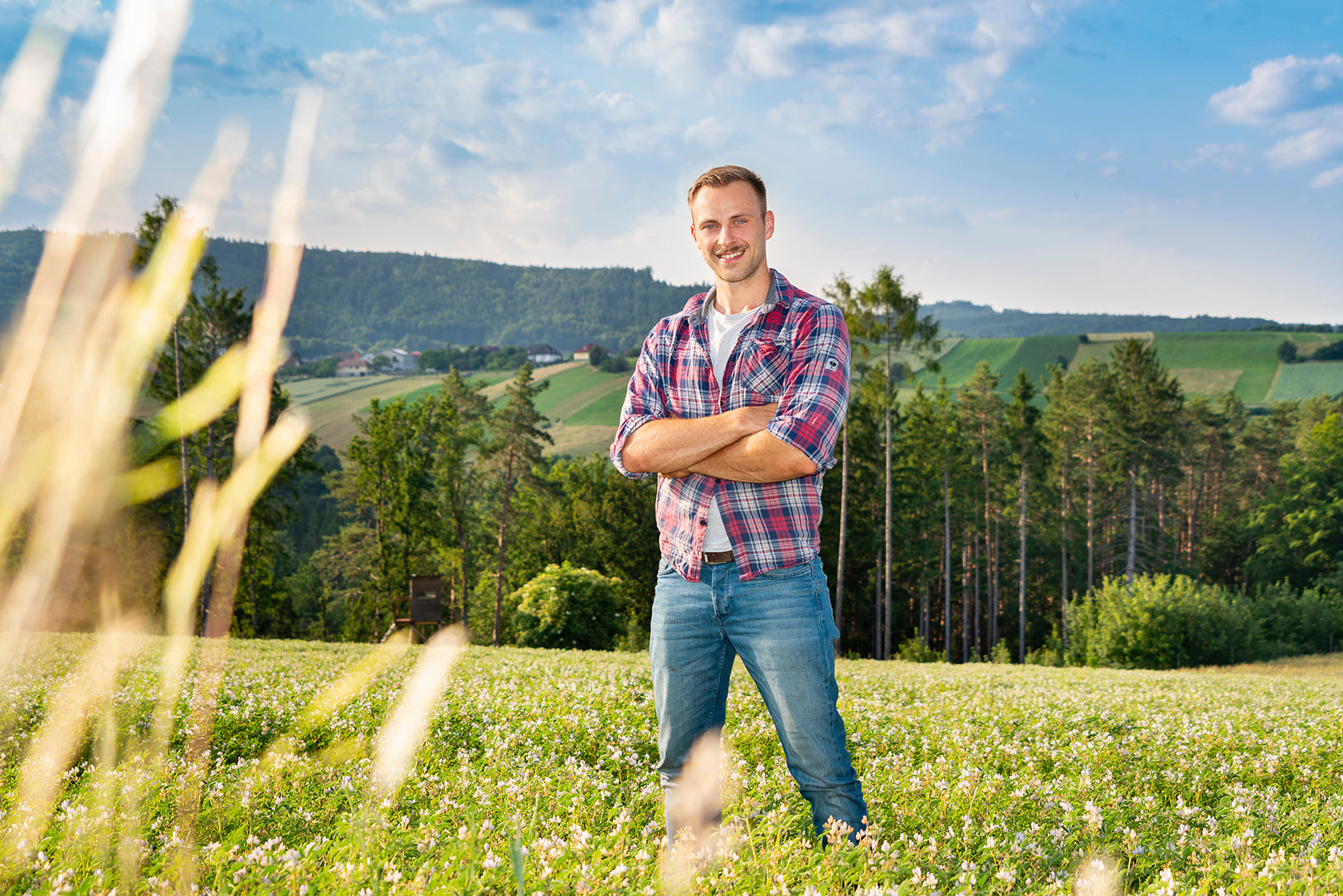 Jakob Schindele steht am Feld wo die Lupinen wachsen.